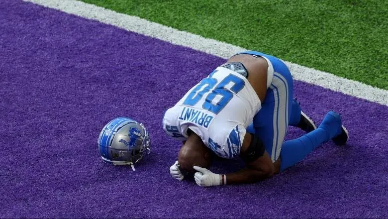 Austin Bryant kneeling in prayer in the end zone